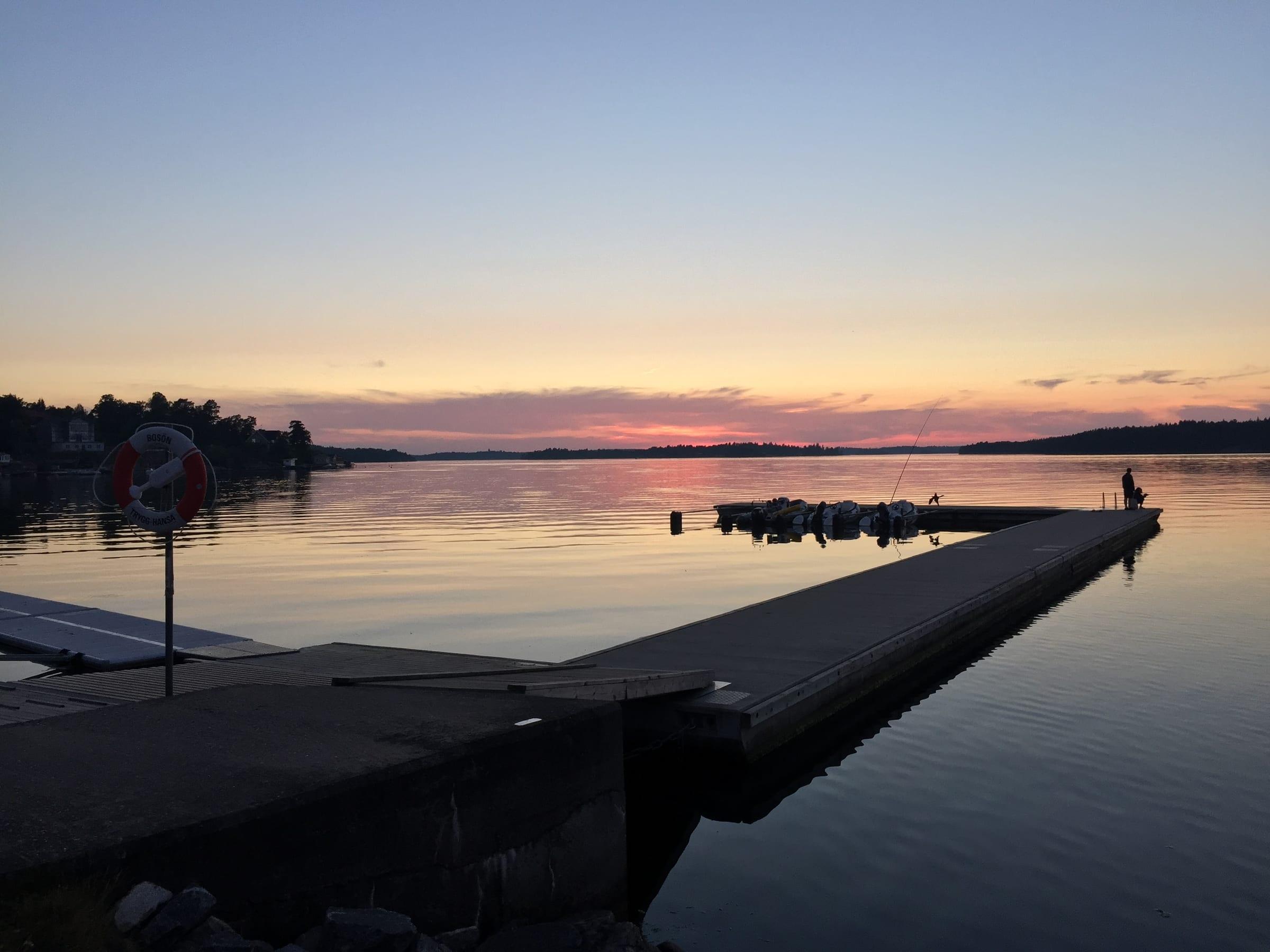 Sunset over a calm Scandinavian dock with fishing boats